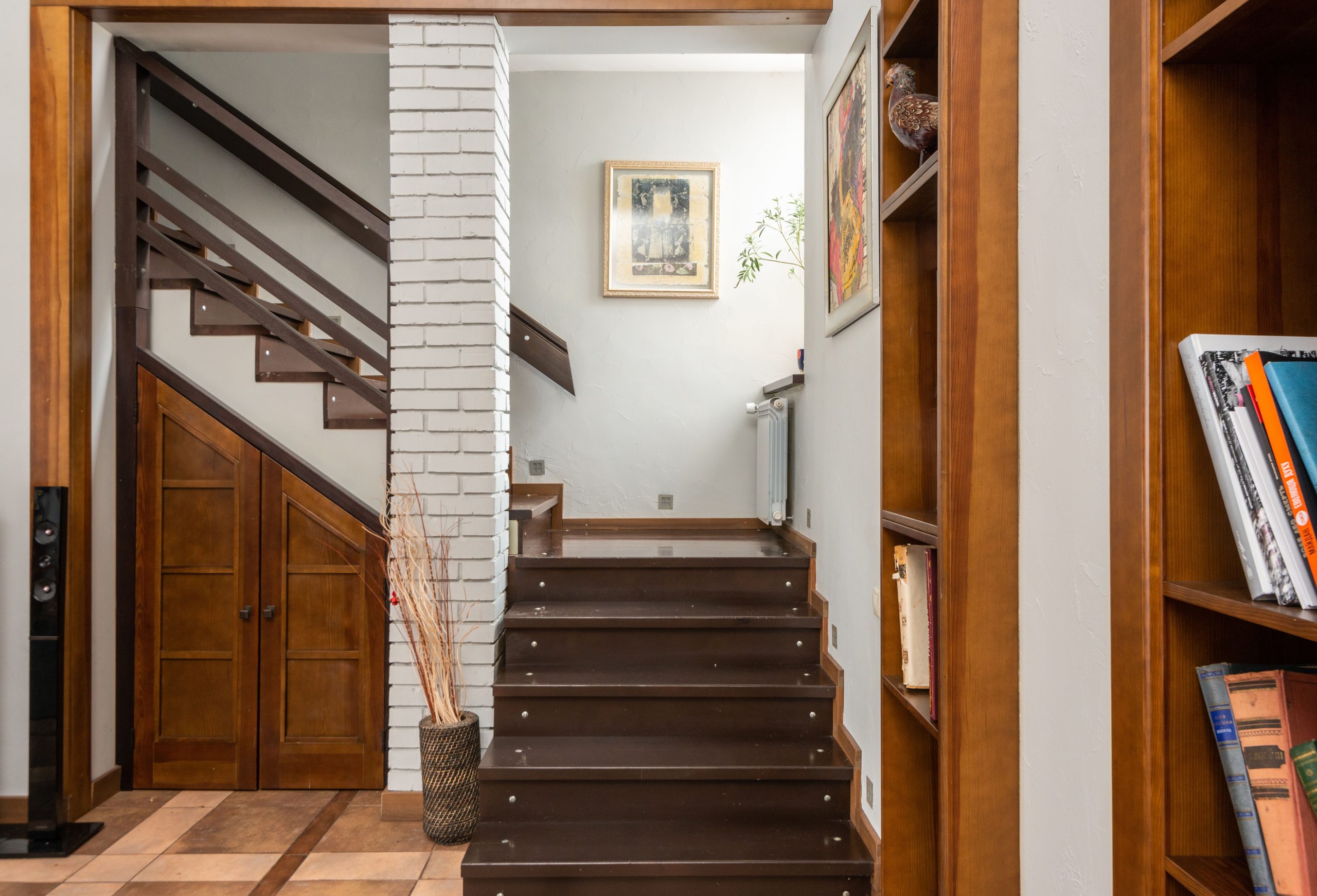 Escalier bois près colonne brique avec papier peint