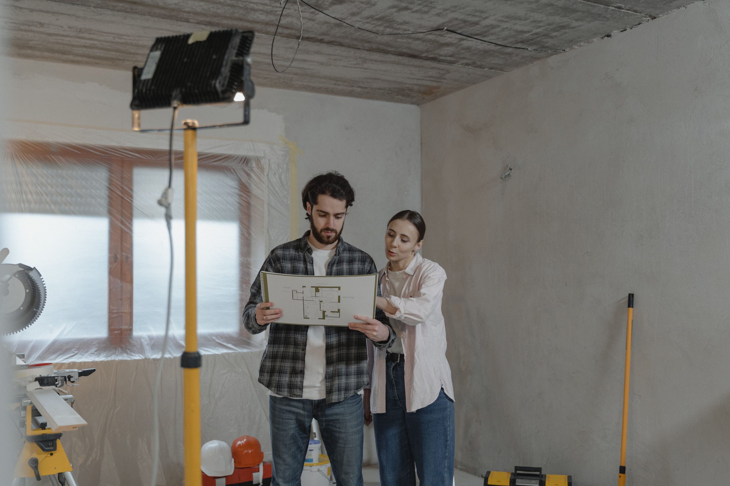 Couple étudiant des plans dans une pièce en rénovation