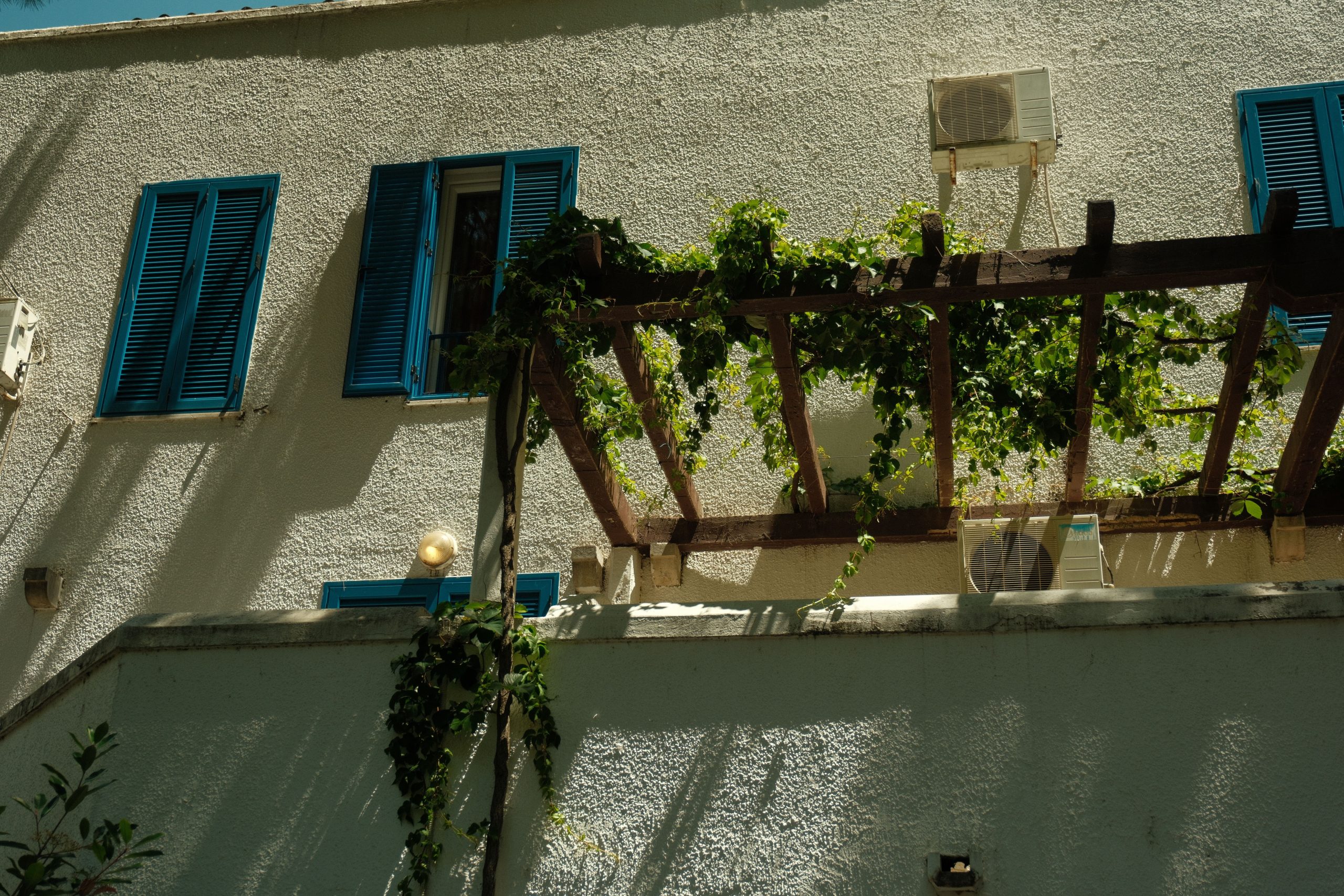 Batiment mediterraneen volets bleus verdure luxuriante