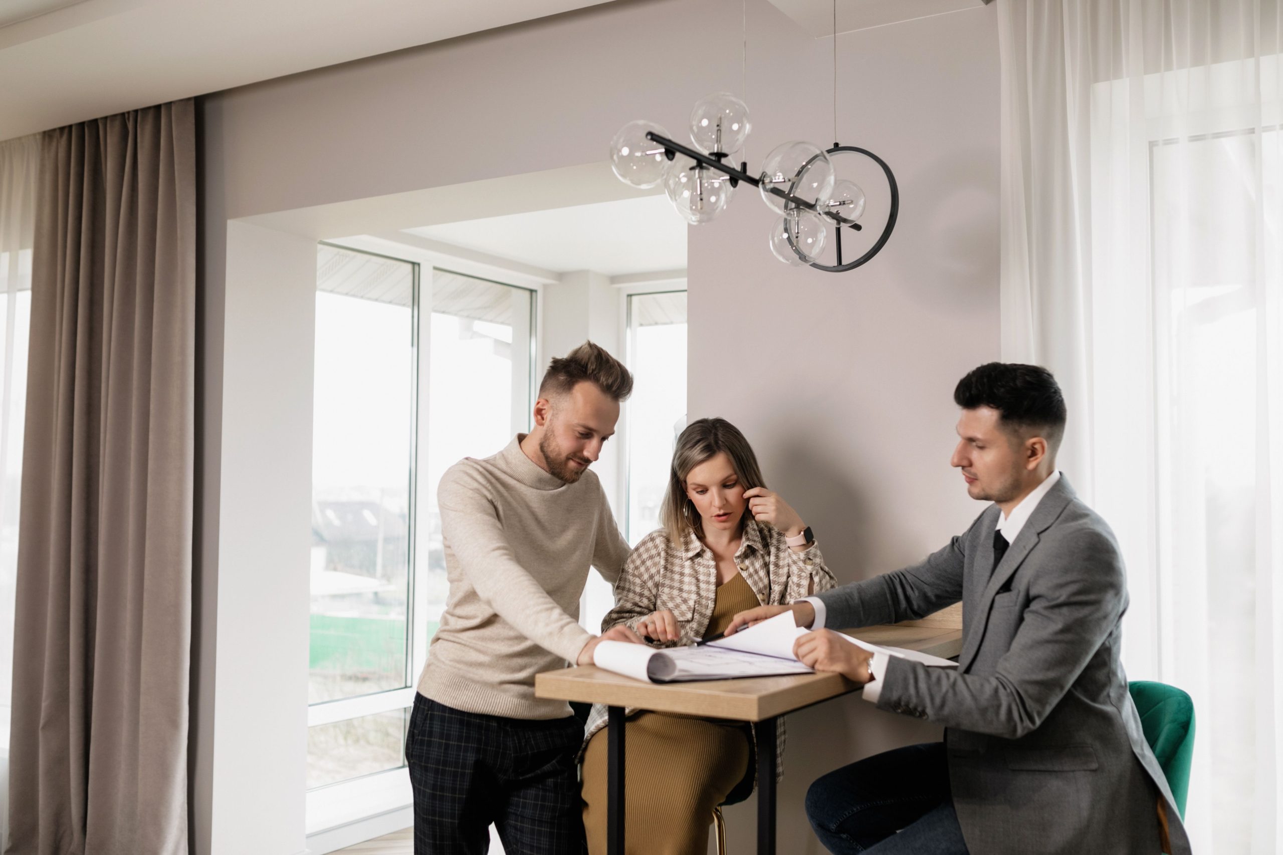 Couple consulte agent immobilier pour documents propriété