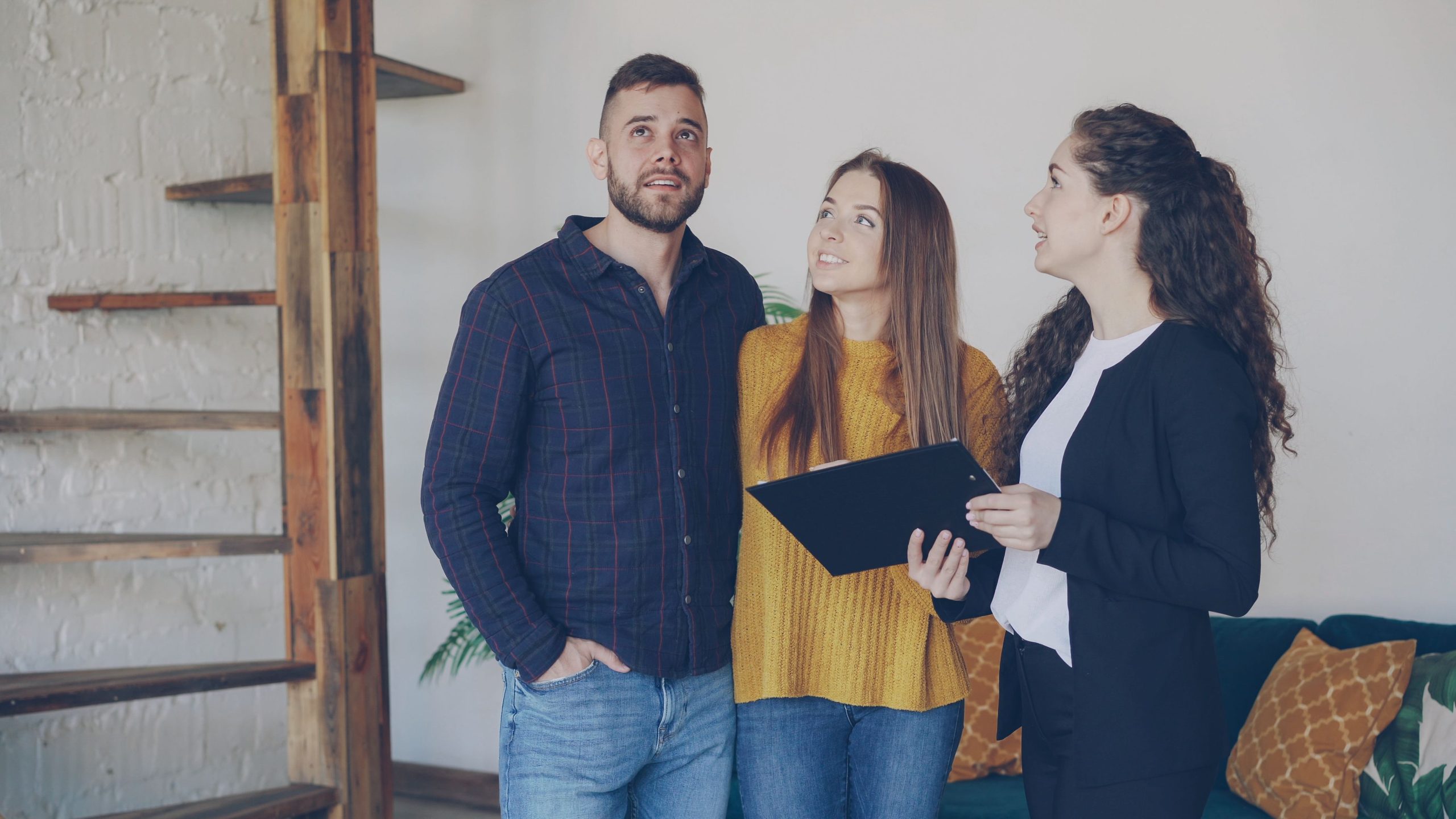 Jeune couple explorant nouvelle maison avec agent