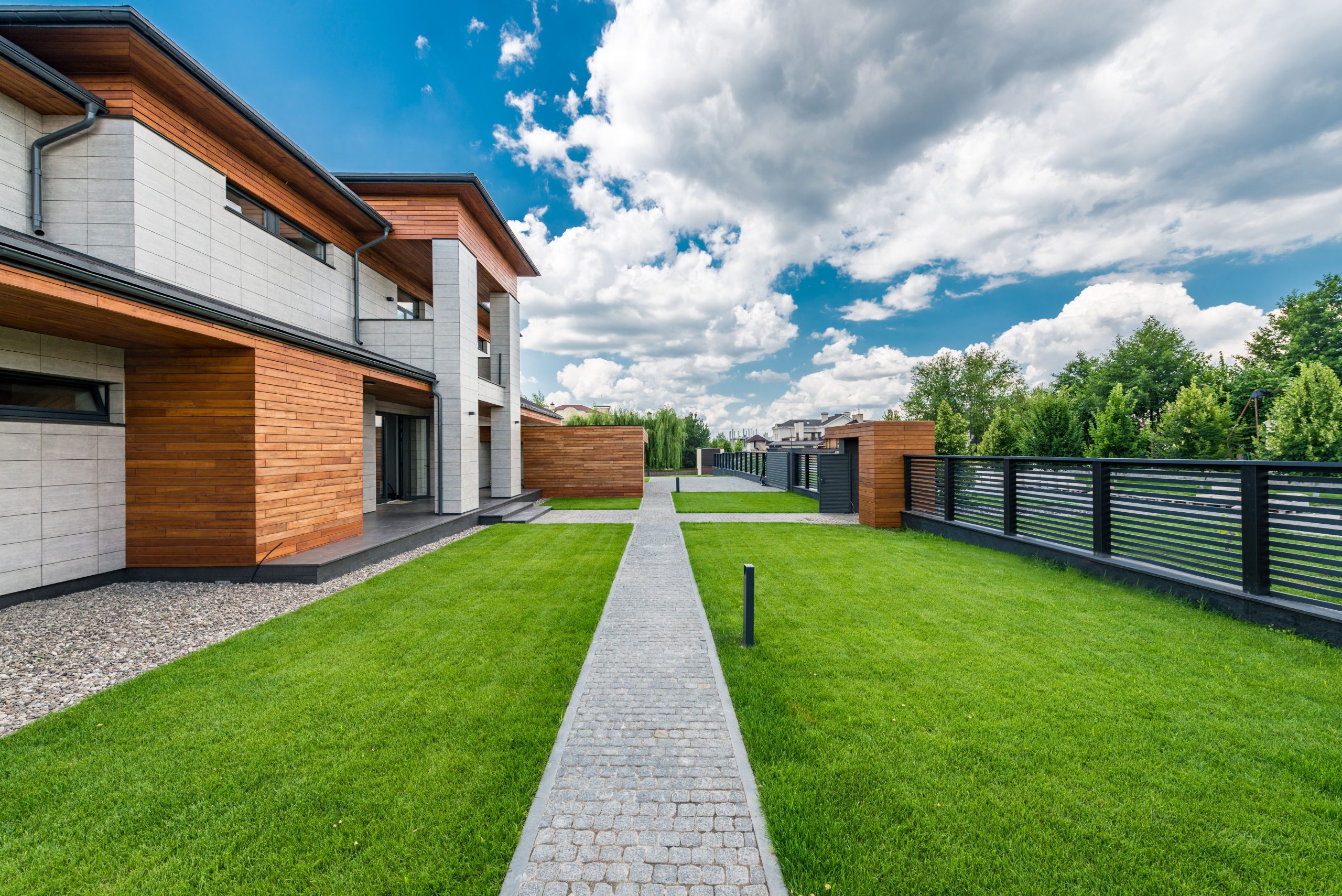 Jardin vert avec arbres devant maison moderne