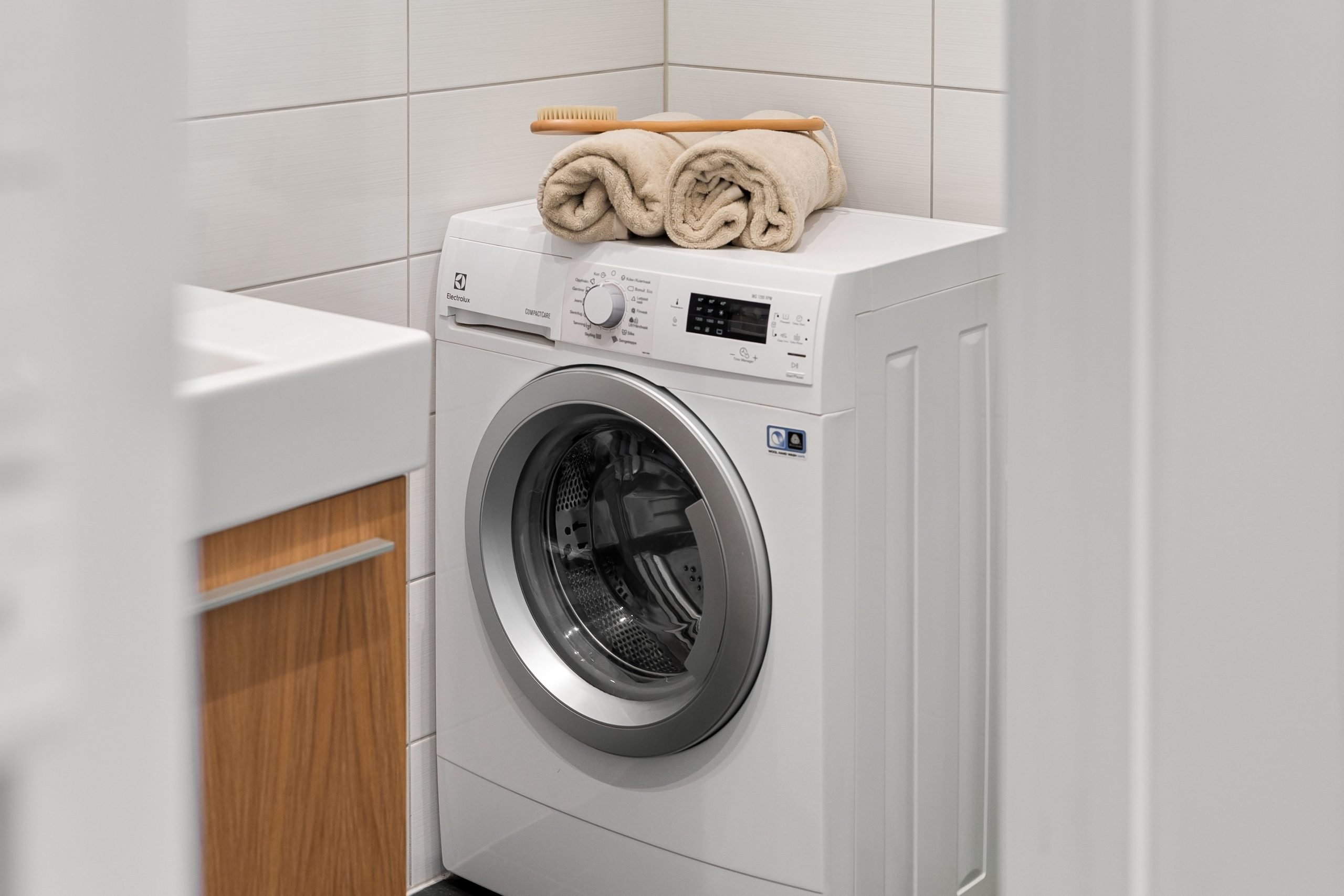 Buanderie propre avec machine à laver blanche et serviettes