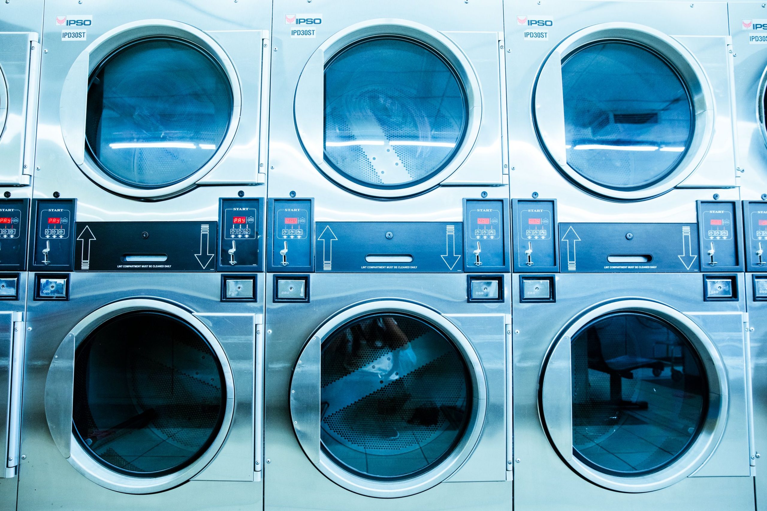 Rangée de machines à laver modernes en laverie automatique