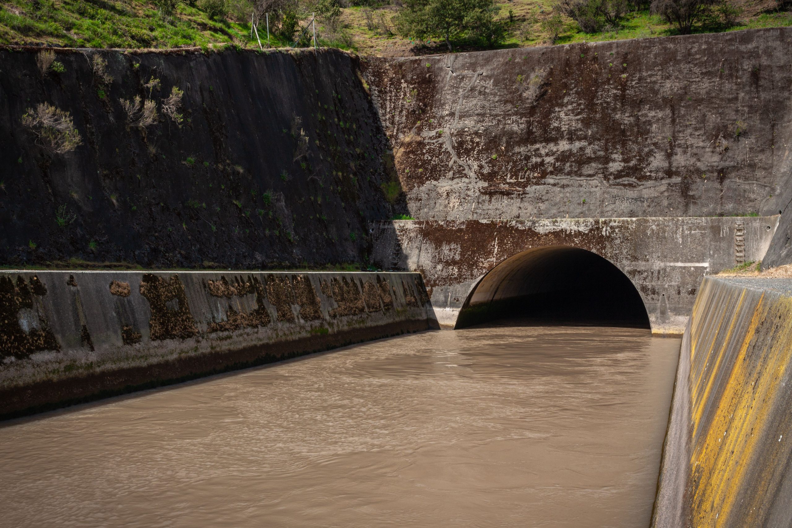 Puisard béton avec eau s'écoulant dans tunnel